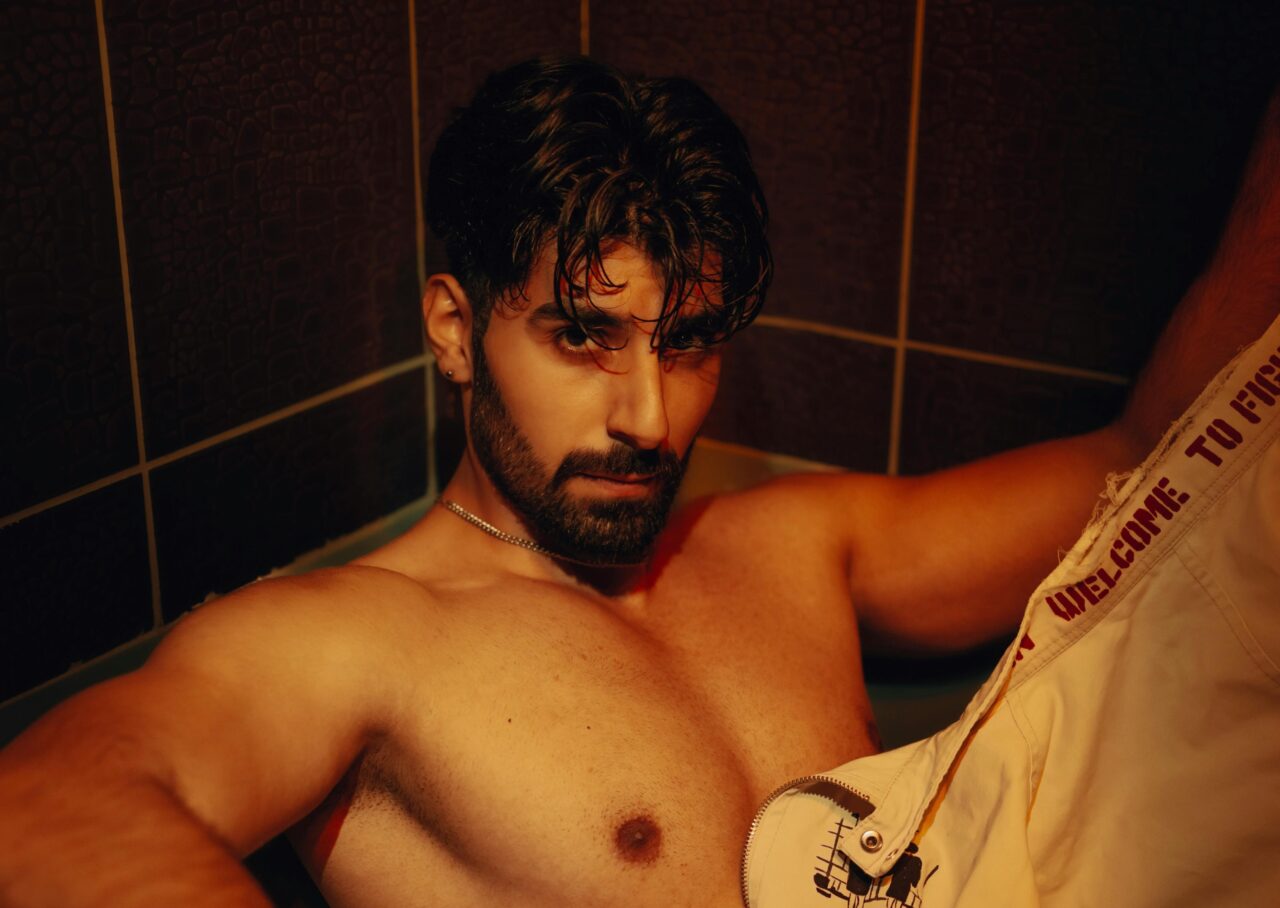 A captivating portrait of a bearded man posing in a bathroom in İstanbul, highlighting his intense gaze.