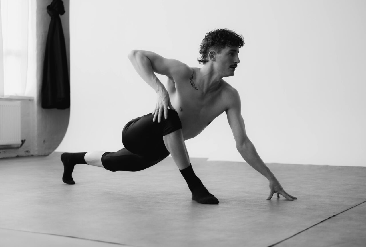 A male dancer striking a graceful pose in a Berlin studio.