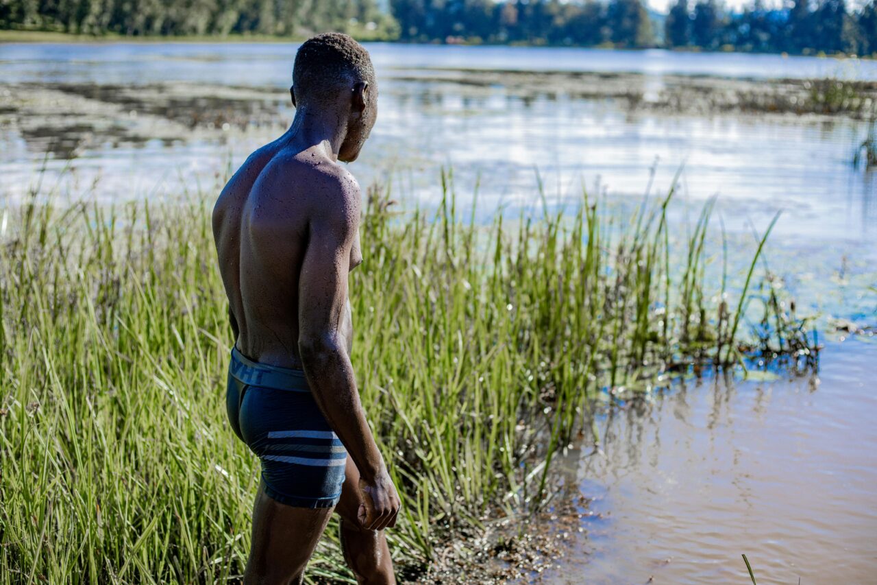 A man enjoys a peaceful moment by the lakeside, surrounded by nature's beauty.